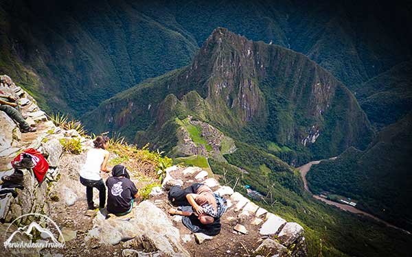 Tourists resting on the summit of Machu Picchu mountain